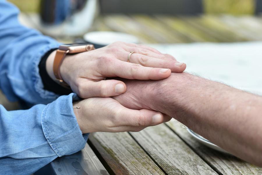 Jemand hält die Hand einer anderen Person