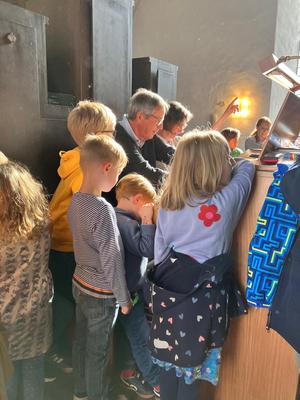 Kinder beobachten das Orgelspiel.